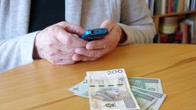 Seniorka z telefonem i pieniędzmi