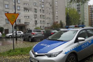 policja, w tle blok mieszkalny
