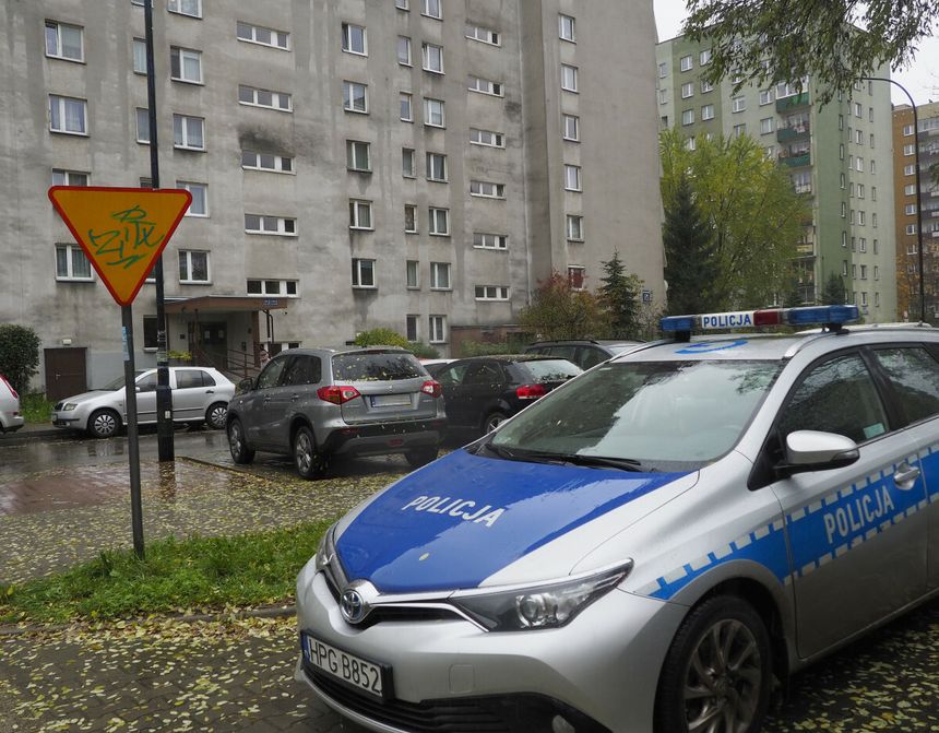 policja, w tle blok mieszkalny