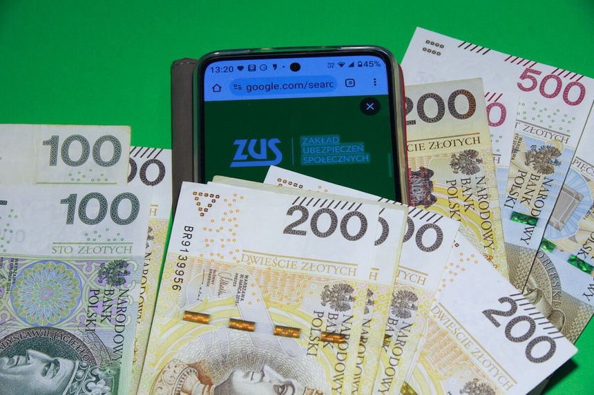 logo ZUS na telefonie i pieniądze