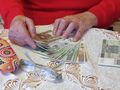 Starsza kobieta seniorka liczy pieniądze z zasiłku