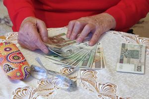 Starsza kobieta seniorka liczy pieniądze z zasiłku