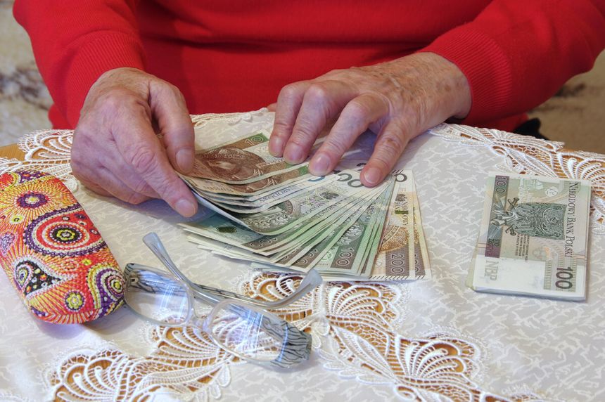 Starsza kobieta seniorka liczy pieniądze z zasiłku