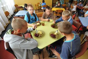 Dzieci jedzą obiad w stołówce szkolnej 