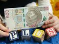 500 zł w rękach dziecka i napis plus z klocków