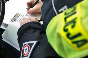 Policjant wypisuje mandat kierowcy 