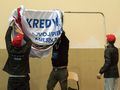 mężczyźni rozwieszający baner z napisem Kredyt