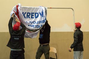 mężczyźni rozwieszający baner z napisem Kredyt