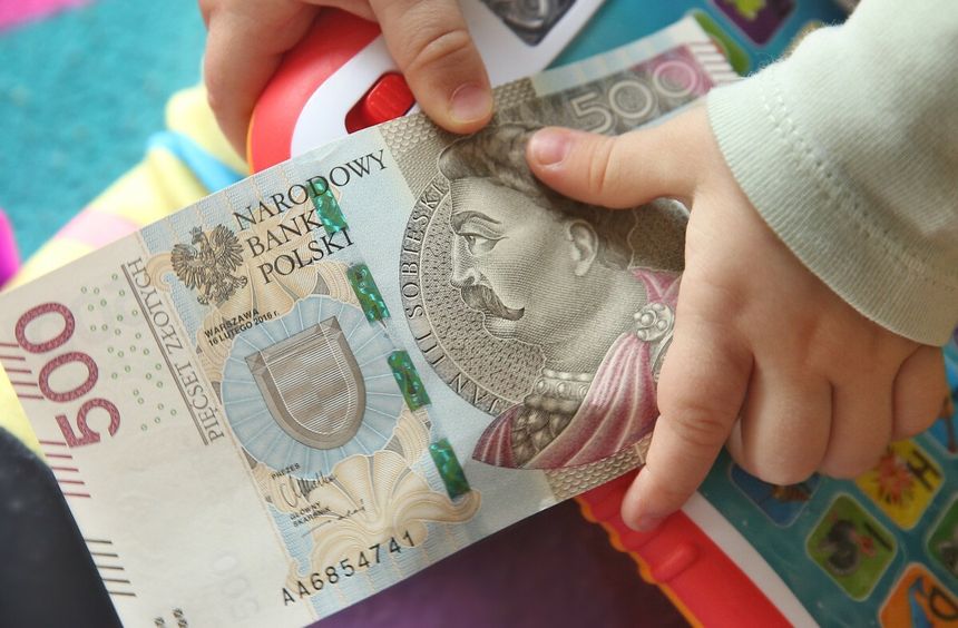 dziecko trzymające banknot 500 zł