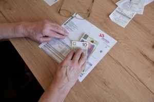 rachunek za energię elektryczną i kilka banknotów na stole
