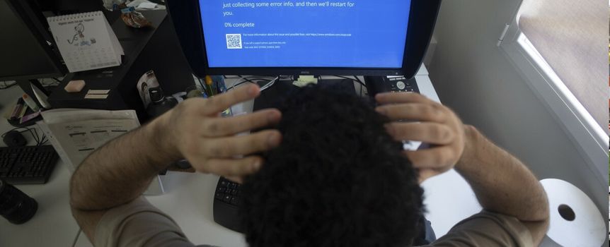 mężczyzna przed komputerem z BSOD