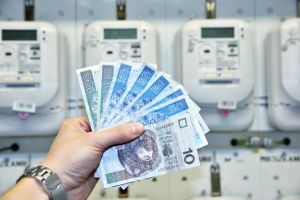 pieniądze trzymane przed licznikami energii elektrycznej