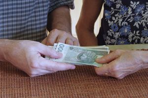 pieniądze przekazywane z ręki do ręki przez seniorów