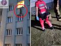 Mężczyzna wiszący w oknie budynku