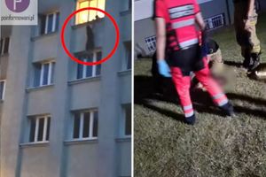 Mężczyzna wiszący w oknie budynku