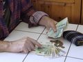 pieniądze liczone na stole prze seniora
