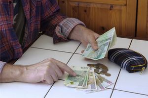pieniądze liczone na stole prze seniora