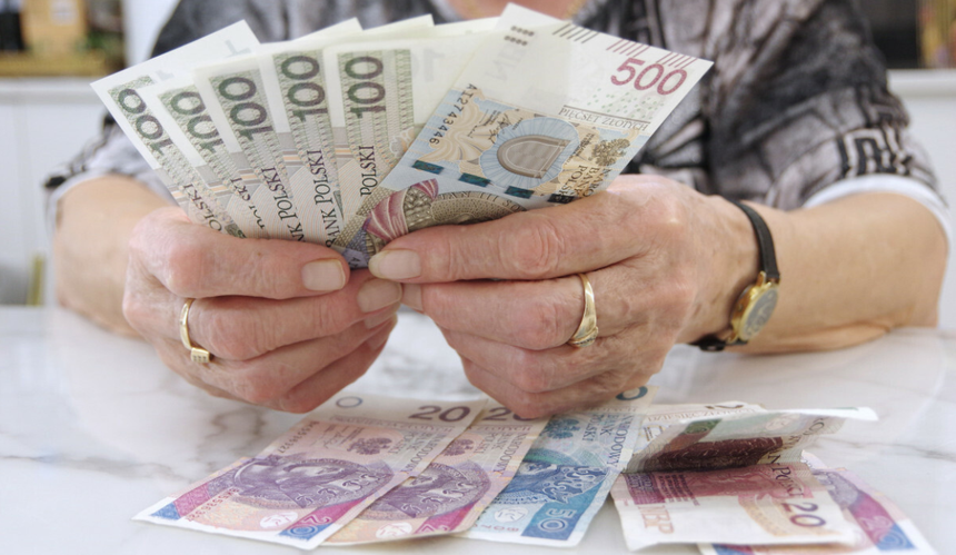 starsza kobieta trzyma pieniądze w ręce