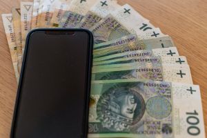 smartfon leżący na pieniądzach