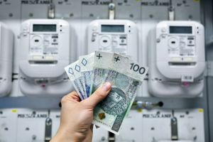 pieniądze trzymane przed licznikami energii elektrycznej