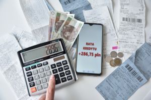 kalkulator, pieniądze, paragony i informacja o wzroście raty