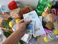 paragon i pieniądze trzymane nad zakupami spożywczymi
