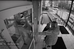 kobieta z dzieckiem wchodząca na komendę policji
