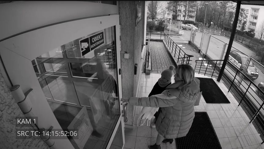 kobieta z dzieckiem wchodząca na komendę policji