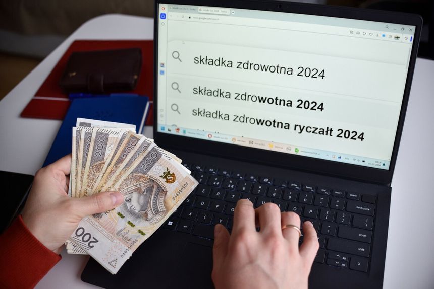 mężczyzna z pieniędzmi przed komputerm z napisem składka zdrowotna 2024 na ekranie