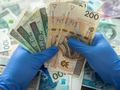 banknoty trzymane w rękawiczkach