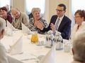 Mateusz Morawiecki przy stole z seniorami