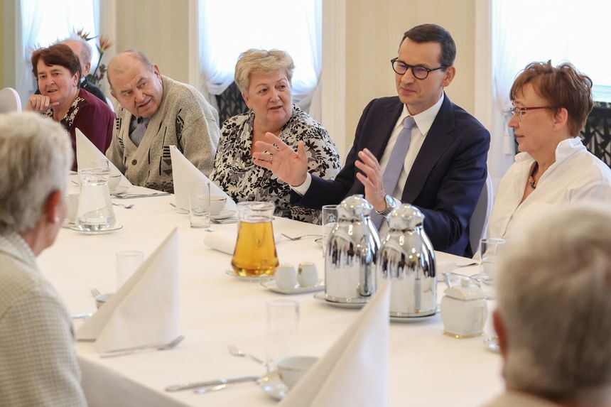 Mateusz Morawiecki przy stole z seniorami