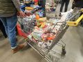 mężcyzna z koszykiem pełnym zakupów w sklepie