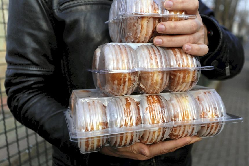 pączki w opakowaniach trzymane w rękacj