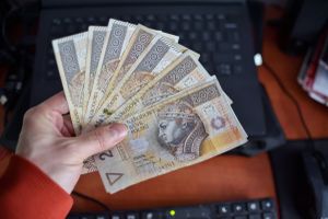 Pieniądze trzymane w ręku przed komputerem