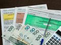deklaracje PIT, pieniądze, długopis i kalkulator