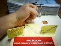 zaciśnięta pięść i karteczki z napisami podatek VAT, dochodowy, polski ład