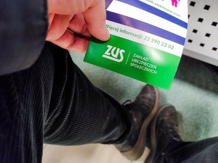 mężczyzna trzymający ulotkę ZUS