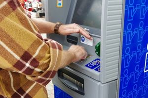 kobieta wypłacająca pieniądze z bankomatu
