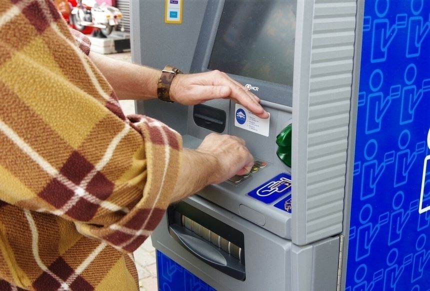 kobieta wypłacająca pieniądze z bankomatu