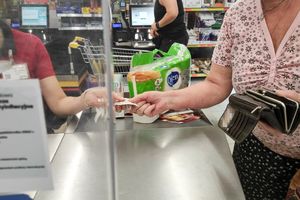 seniorka płacąca za zakupy
