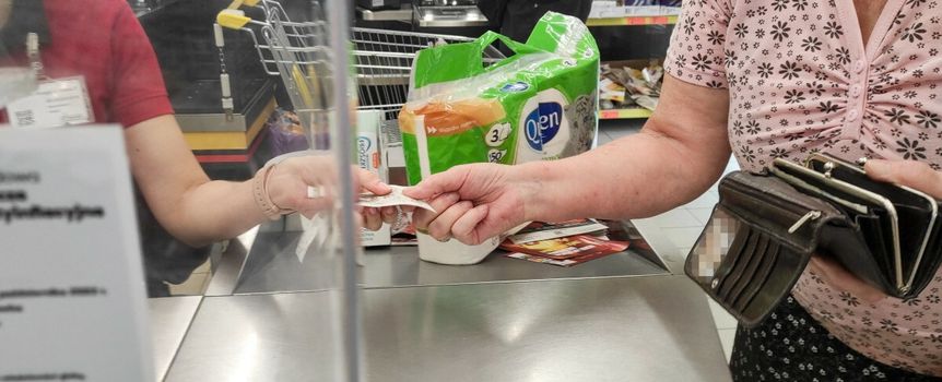 seniorka płacąca za zakupy