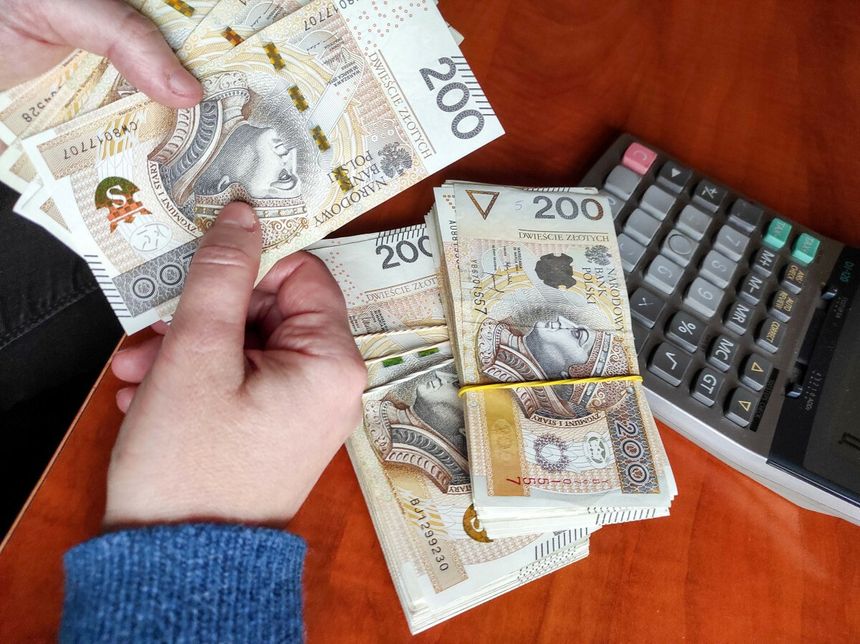 plik banknotów trzymany w ręku