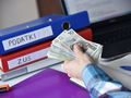 pieniądze na tle segregatorów podatki i ZUS