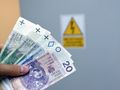 pieniądze trzymane przed skrzynką elektryczną