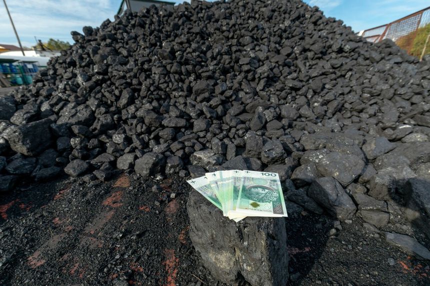 kopa węgla i plik banknotów