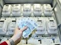 pieniądze trzymane przed licznikami energii elektrycznej