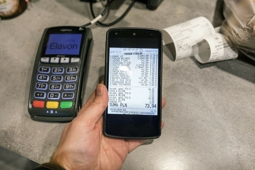 terminal płatniczy, smartfon i papierowy paragon