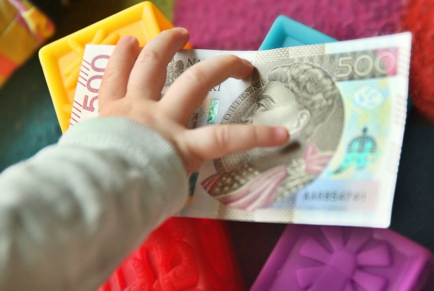 dziecko sięgające po banknot 500 zł