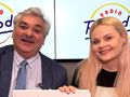 Mężczyzna i kobieta uśmiechają się, trzymając książkę, w tle logo radia